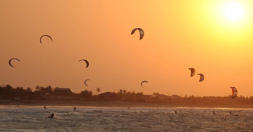 Kitesurfistas na praia de Barra Grande - PI durante o pôr do sol, praticando o esporte na alta temporada de ventos. Kitesurfistas na praia de Barra Grande - PI durante o pôr do sol, praticando o esporte na alta temporada de ventos.
