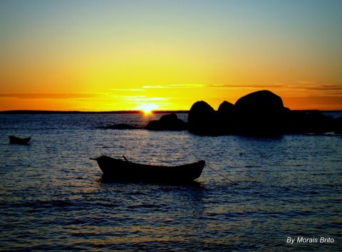 Pôr do sol com barcos de pesca ancorados na parte mansa da Praia da Pedra do Sal, conhecida por sua beleza rústica e por ser a única praia da cidade de Parnaíba.