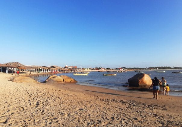 Alguns barcos de pesca e turistas explorando a beleza da Praia da Pedra do Sal.